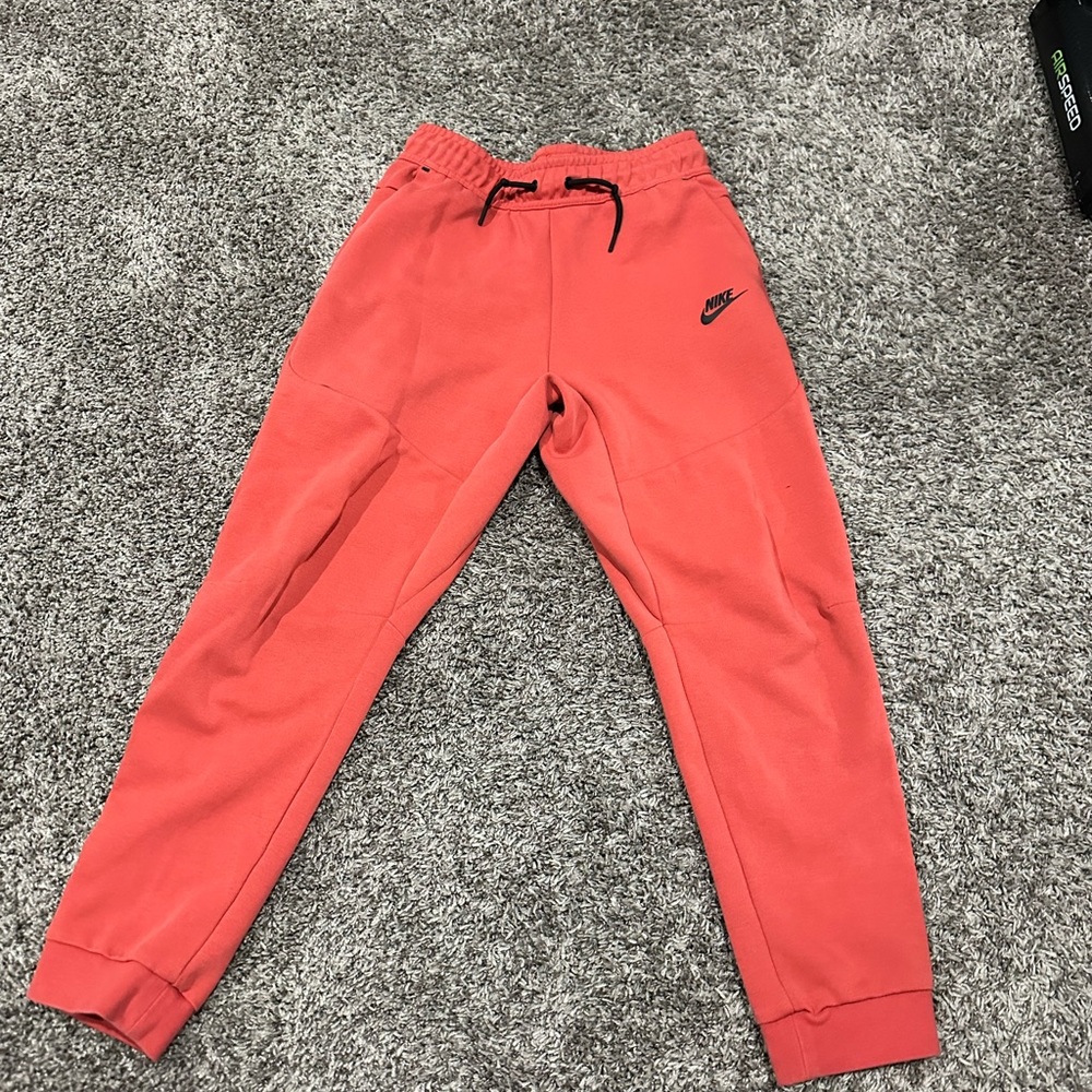 Red Nike tech pants